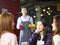 Young smiling asian waiter serving coffee to customers