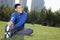 Young smiling athletic man stretching in Beijing Park- Horizontal