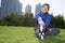 Young smiling athletic man stretching in Beijing Park- Horizontal