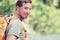 Young smiling backpack man in summer forest nature