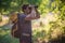 Young smiling backpack man in summer forest nature. Happy handsome male adult student looking at camera walking hiking in forest