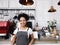 Young smiling barista wearing apron