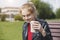 young smiling blonde girl holding paper coffee cup, enjoying coffee, having fun