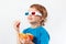 Young smiling boy in stereo glasses eating popcorn