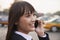 Young smiling businesswoman using the phone outside on the street in Beijing, close up portrait