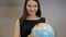 Young smiling businesswomen with globe, happy brunette woman choose travel
