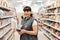 A young smiling Caucasian woman who works as a Manager in a supermarket, posing between the food rows, in the aisle. Business and