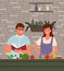 Young smiling couple in aprons making salad together, preparing vegetarian food at home in kitchen