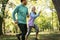 Young smiling couple running at park. Exercise in nature.