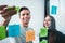 Young smiling coworking team post it notes sticky on glass wall while working and business meeting in office studio