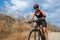 Young smiling cyclist in black sportswear riding a mountain bike. Outdoor sports activity, lifestyle concept