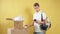 Young smiling delivery man with boxes isolated