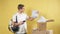 Young smiling delivery man with boxes isolated