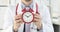 Young smiling doctor holds red alarm clock at ten in morning 4k movie