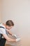 Young Smiling Electrician Installing Electrical Socket On Wall In House