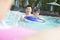 Young smiling family splashing and playing in the pool