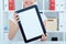 Young smiling female secretary holding tablet in hands sitting at office. Tablet with empty space for advertising.