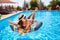 Young smiling fitted girl in bikini, straw hat relax on inflatable swan in swimming pool. Attractive woman in swimwear