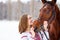 Young smiling girl enjoying friendship with horse