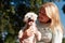 Young smiling girl hug adorable furry Maltese dog