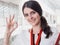 Young Smiling Girl Made Successful Work Shows Gesture Big Thumb Up. Beautiful Smiling Businesswoman Standing Against White Offices