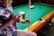 Young smiling girl playing billiard in club