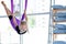 young smiling girl practice in aero stretching swing in purple hammock in fitness club. kids Aerial flying yoga
