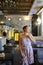 Young smiling girl standing at cafe, tables and chairs in backround.