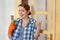 Young smiling girl worker, painting new wooden door