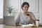 Young smiling italian woman in casual clothes looking at credit card and typing on laptop