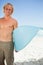 Young smiling man holding his blue surfboard