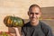 Young smiling man holds a pumking on one hand