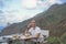 Young smiling man in Nature, Enjoying Meal with Majestic Mountains and Sky Background in summer vacation