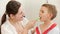 Young smiling mother brushing and cleaning teeth of her little son with toothbrush. Concept of child dental hygiene and