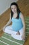 Young smiling pregnant woman in a meditative pose.