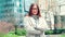 Young smiling professional business woman standing on big street, portrait.