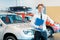 Young smiling salesman with clipboard in car