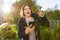 Young smiling teen girl shows index finger up, attention idea eureka, outdoor background, golden hour