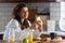 Young smiling woman in bathrobe just got up in the morning in the kitchen using smart phone