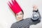 Young smiling woman celebrating party, wearing stripped dress and red paper crown, happy dynamic carnival disco ball