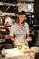 Young smiling woman chef cook preparing meals for a restaurant in kitchen