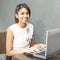 Young smiling woman with computer.