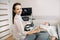 Young smiling woman doctor sonographer using ultrasound machine while conducting ultrasound test of female patient