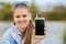 Young smiling woman in excellent spirits with a phone and listens to music