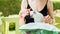 Young smiling woman feeding with milk a white cute kitten from a bottle