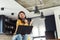 Young smiling woman with headphones working from home, taking break listening music and singing