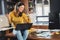 Young smiling woman with headphones working from home, taking break listening music and singing