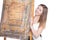 Young smiling woman hiding behind easel