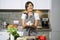 Young smiling woman holding mushrooms in her hands in the kitchen. Proper nutrition and health concept