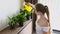 Young Smiling Woman Pouring from Watering Can Growing Flowers